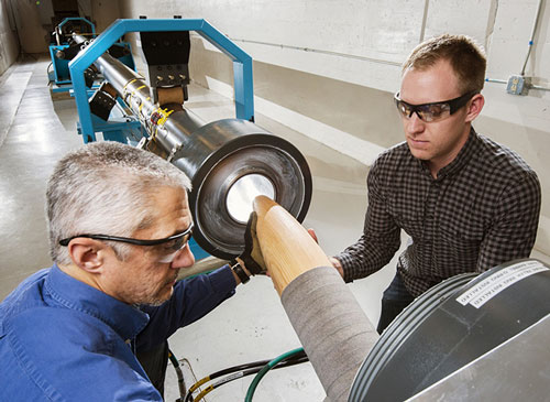 Two researchers holding Davis Gun to prepare for a test